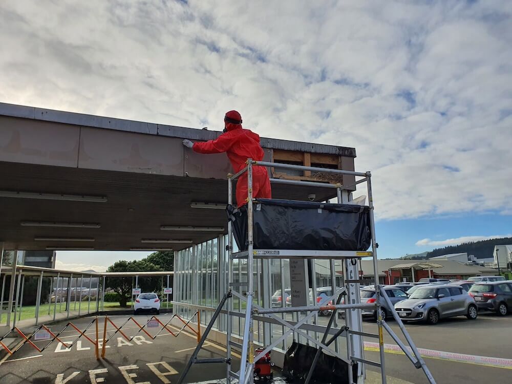 Asbestos Removal Expert working on the roof of a commercial building