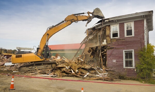 Demolition - An excavator demolishing a house