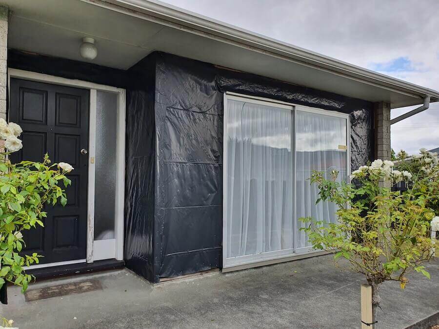 A residence covered by plastic while working on Asbestos Removal